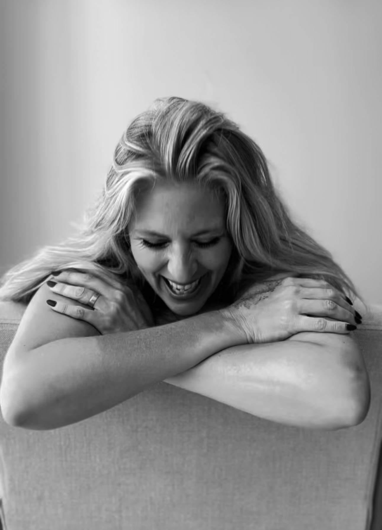 Gayle Berry leaning on a chair, laughing